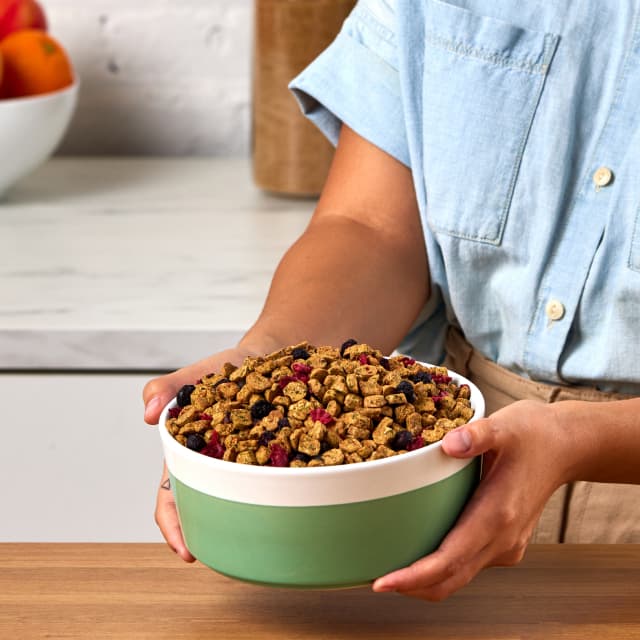 Hands holding green bowl of Fresh Baked Food